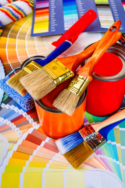 istock Painter and decorator work table with house project, color swatches, painting roller and paint brushes 2003244918