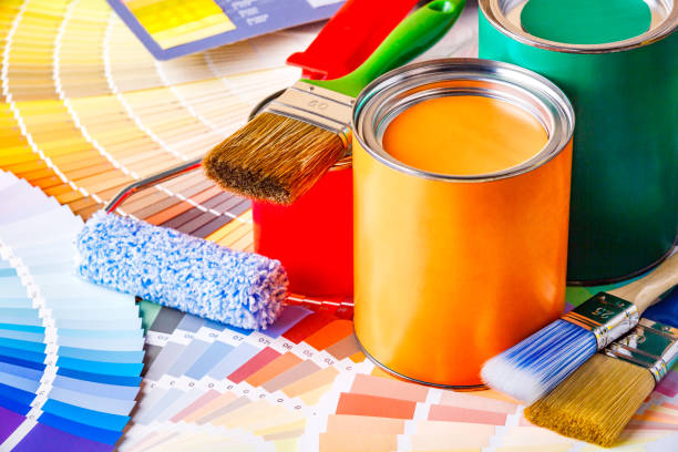 istock Painter and decorator work table with house project, color swatches, painting roller and paint brushes 2003244919