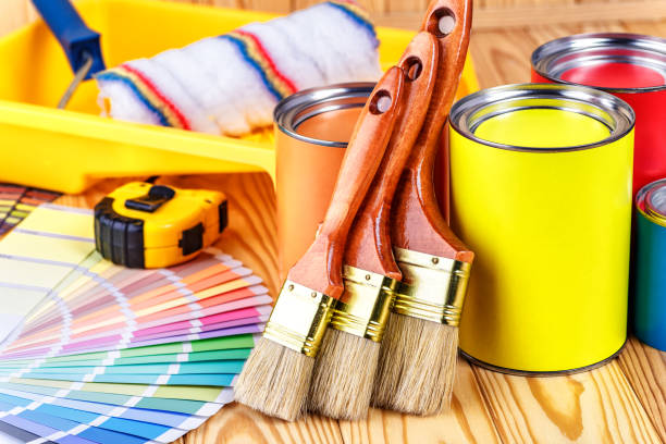 istock Painter and decorator work table with house project, color swatches, painting roller and paint brushes 2003245439