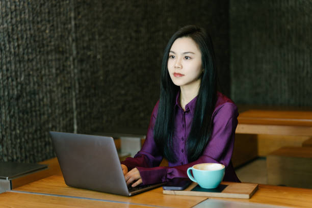 istock Asian young businesswomen using Mobile phone in a coffee shop 2003280024
