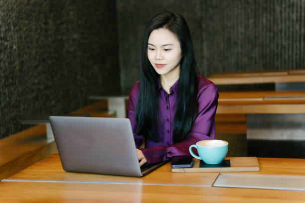 istock Asian young businesswomen using laptops in a coffee shop 2003280028