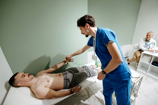 Medical professional connects the patient to the EKG