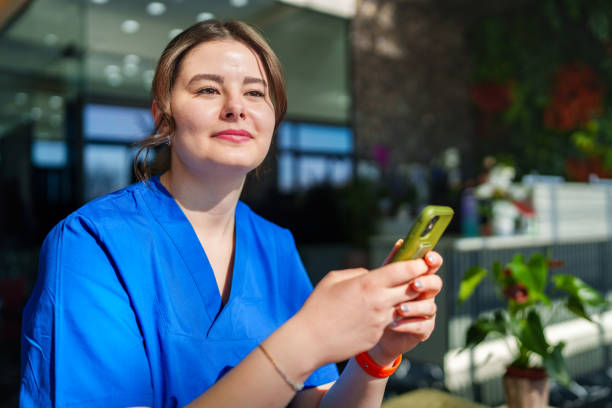 istock Healthcare worker using mobile phone at the clinic lobby 2003320641