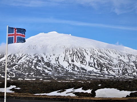 Snfellsjkull mountain covered of snow with the flag of iceland in the foreground