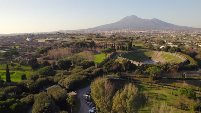 Impressive Roman amphitheater revealed with mount Vesuvius behind. Aerial