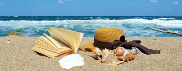istock Book ,hat and seashells on the beach 2003353810