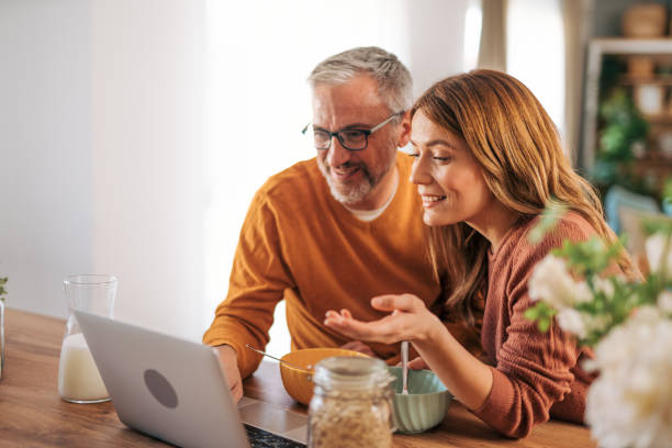 istock Mature couple using laptop and having breakfast. 2003373904