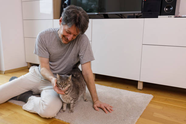 istock Man Sitting on the Floor Petting His Cat 2003381329
