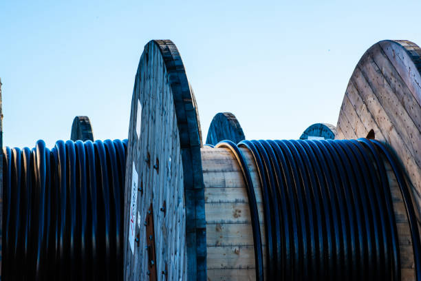 istock Large wooden cable drums with black cable.. 2003382919
