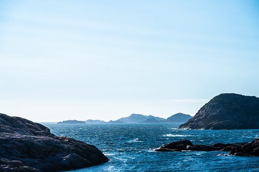 Rough seas by tall rocky cliffs.