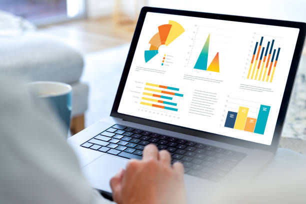istock Man working on a computer with financial data at home. laptop showing charts and graphs 2003405515