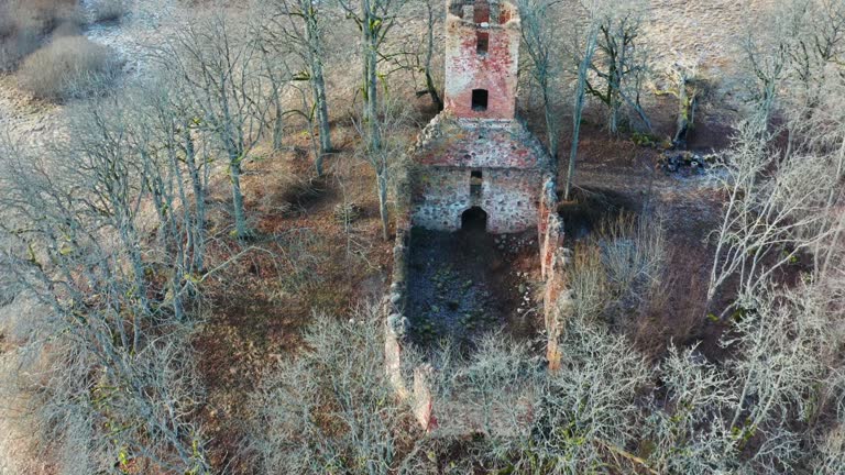 Aerial view of countryside church bell tower and stone boulder wall remains