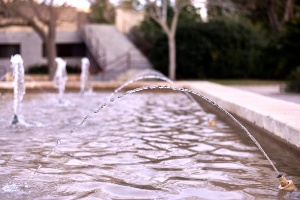 jet d’eau d’une fontaine sur un arrière-plan flou - fountain pen flash photos et images de collection