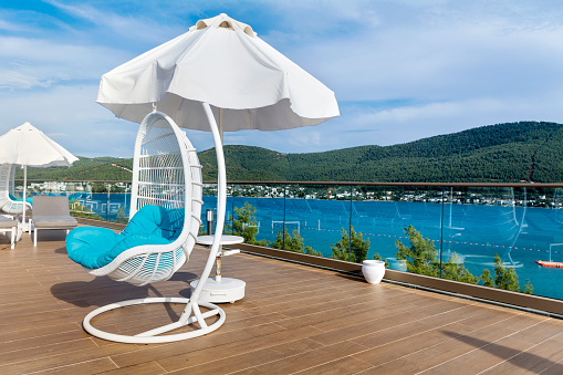 Comfortable hanging chair on the open house terrace with sea view