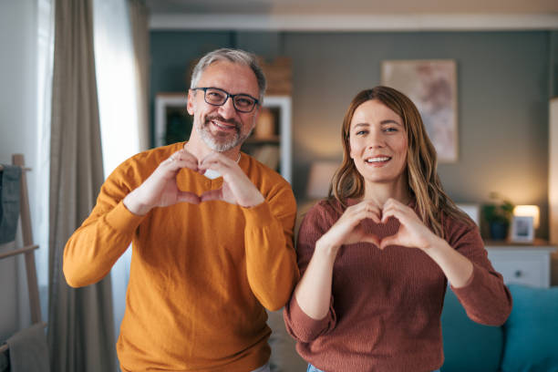 istock happy mature couple making heart shape with hands 2003462803