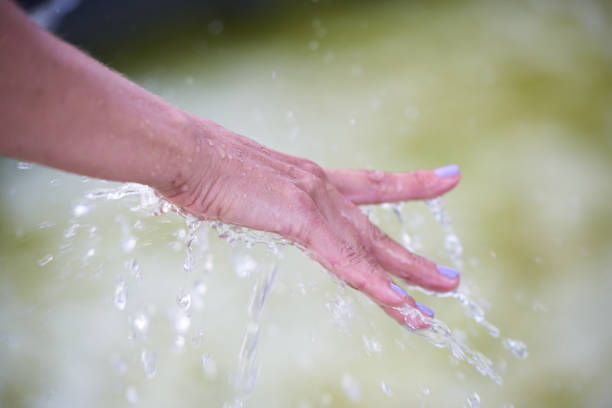Close up of unrecognizable woman showering in the bathroom.