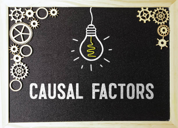 istock On a light wooden table - a board with the text CAUSAL FACTOR, pencils, plants, glasses and paper clips. 2003502097