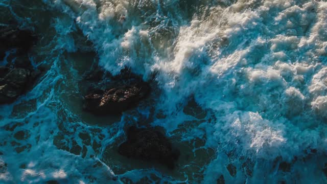 Wave sea turquoise rolling slow crash rocks pattern coastline sunset paradise island.