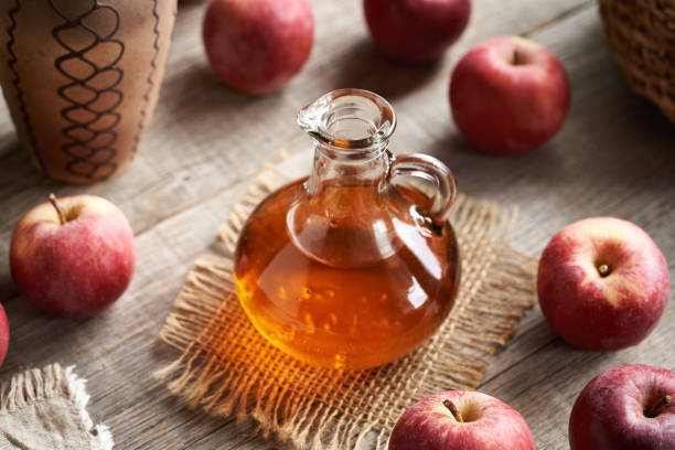 istock Apple cider vinegar in a glass jug and fresh red apples 2003517293