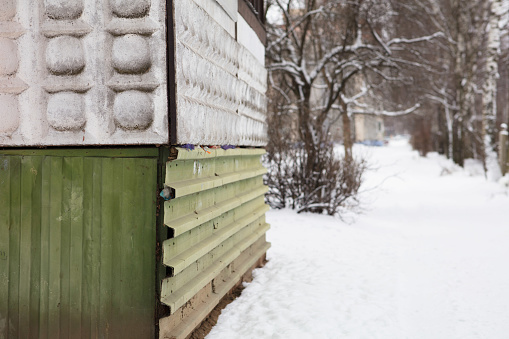 An eerily deserted and snow-covered path leads to Soviet-style concrete apartment buildings.