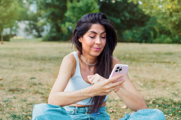 istock Young woman using phone in city park 2003543845