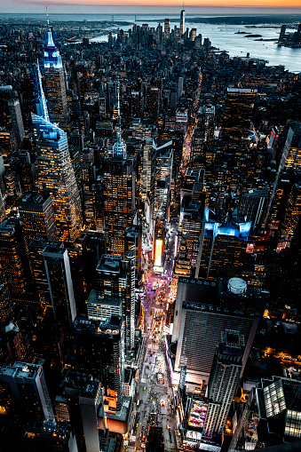 Helicopter point of view of famous Times Square in New York City and all the famous skyscrapers during the blue hour which is just after sunset.