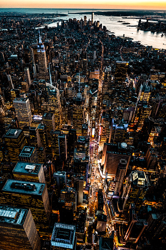 Helicopter point of view of famous Times Square in New York City and all the famous skyscrapers during the blue hour which is just after sunset.