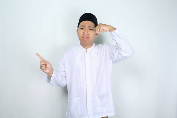istock sad asian muslim man crying with pointing to empty space isolated on white background 2003601106