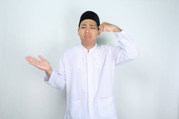 istock sad asian muslim man crying with presenting hand to empty side isolated on white background 2003602145
