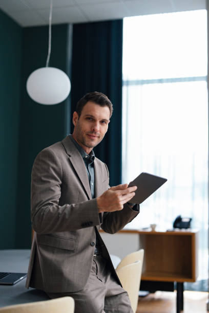 istock Confident Businessman Holding Tablet in Modern Office 2003612519
