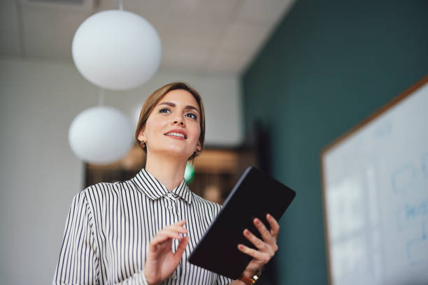 istock Confident Businesswoman Presenting Ideas Holding Tablet 2003613049