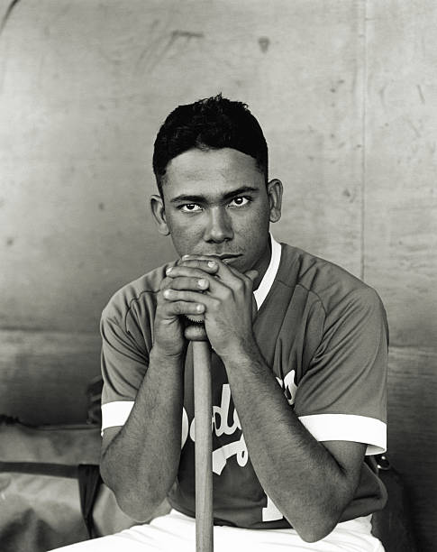 baseball player leaning on bat, portrait (b&w) - baseball player baseball holding bat zdjęcia i obrazy z banku zdjęć