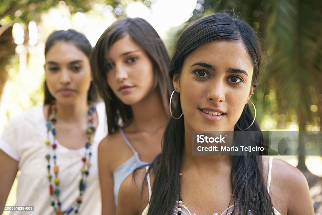Teenage girl (16-18), улыбается, портрет, молодые женщины в backgroun - Стоковые фото Серьги-кольца роялти-фри