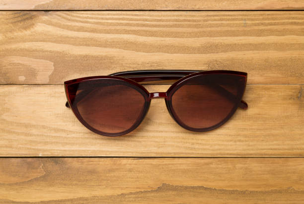 istock Sunglasses on wooden background, top view. 2003659089