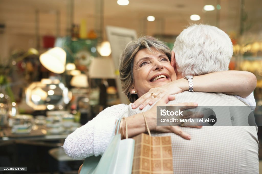 Sênior casal abraçando do lado de fora da loja, mulher sorridente, close-up - Foto de stock de Casal Idoso royalty-free