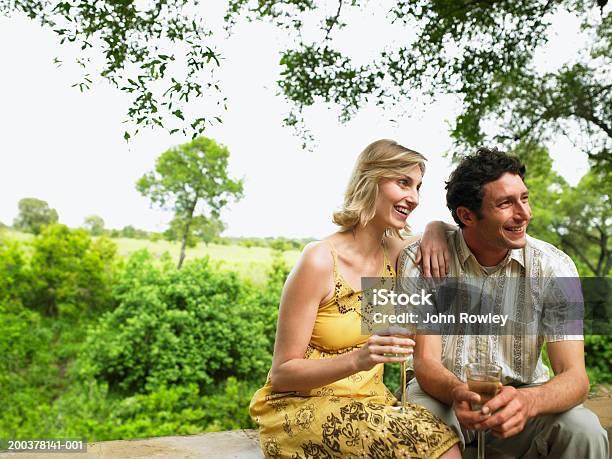 Photo libre de droit de Couple Ayant Un Verre Sur La Terrasse Souriant banque d'images et plus d'images libres de droit de Haute société - Haute société, 30-34 ans, 35-39 ans