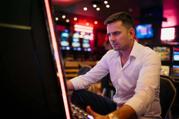 istock Young man loosing his money on a slot machine 2003805118