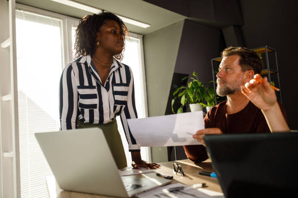 istock Businesswoman leading a meeting and sharing project documents with colleagues 2003809362
