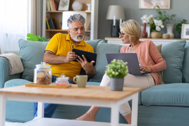 istock A senior couple using a digital tablet and laptop at home 2003811950