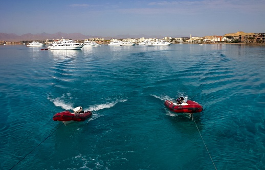 Hurhgada, Egypt - April 9, 2006: Inflatable rubber boats are pulled by a yacht on ropes in the Red Sea, Egypt