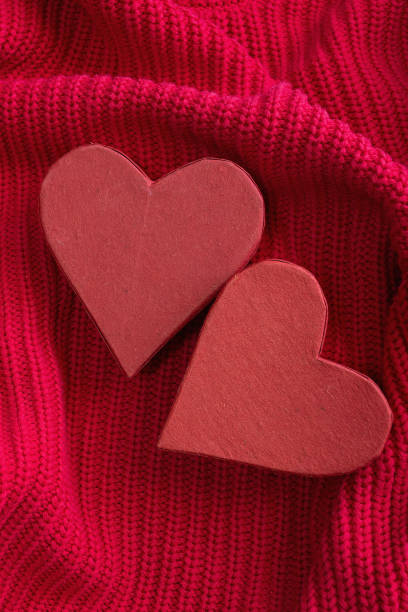 istock Two red hearts on red knitted texture background. Valentines day festive background. 2003827396
