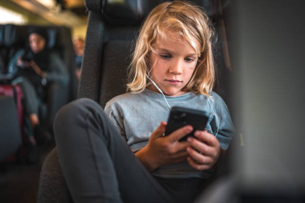 istock Caucasian Boy with Smartphone and Earphones on a Train 2003845236