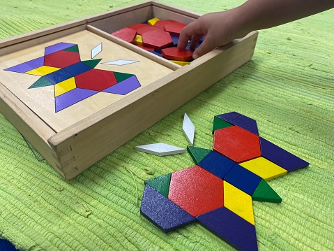 Various Montessori sensorial materials teaching children spatial awareness, as well as concepts of building/grading from small to large, and shape recognition.