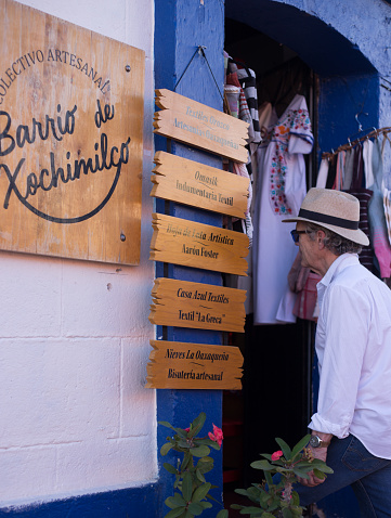 Xochimilco, Oaxaca, Mexico: A tourist enters a craft shop in Xochimilco, a neighborhood near downtown Oaxaca known for its shops and wall murals.