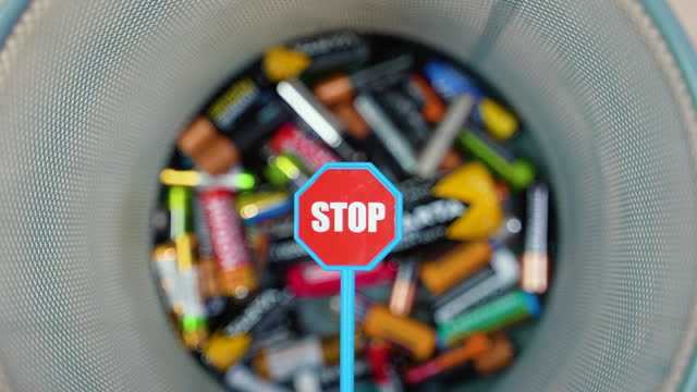 Throw used batteries into the trash. Overflowing used batteries in office garbage bin. Stop pollution by batteries