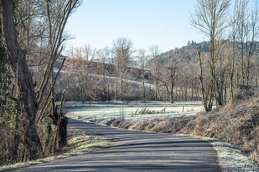Winter landscape in Auvergne, with a road and frost.