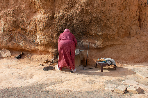 06.11.26 Sahara, Tunisia: Berber woman in traditional clothes bake bread at home. Native Local Tunisian People