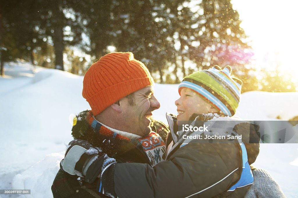 Vater und Sohn (8-10) Umarmen in verschneite Landschaft, Lächeln, clo - Lizenzfrei Winter Stock-Foto