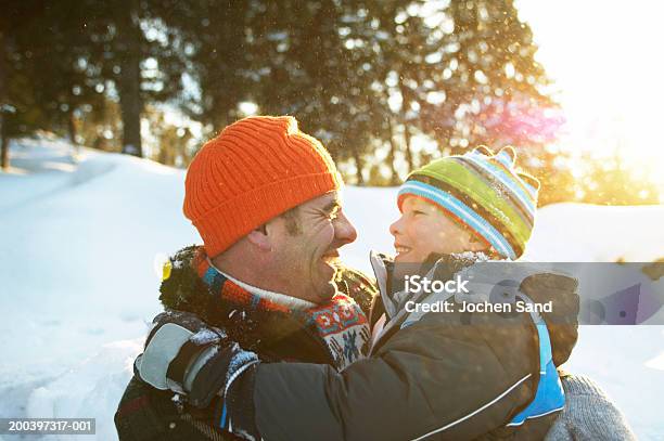 Vater Und Sohn Umarmen In Verschneite Landschaft Lächeln Clo Stockfoto und mehr Bilder von Winter