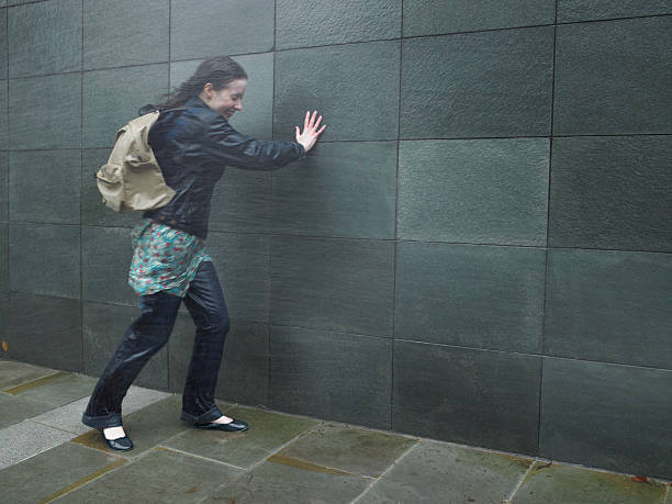 若い女性に悪戦苦闘ウォークインレインストーム、目を閉じた - rain drenched one person standing ストックフォトと画像